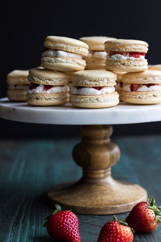Beautiful Strawberry Shortcake Macarons presented on a vertical stand with the dark background