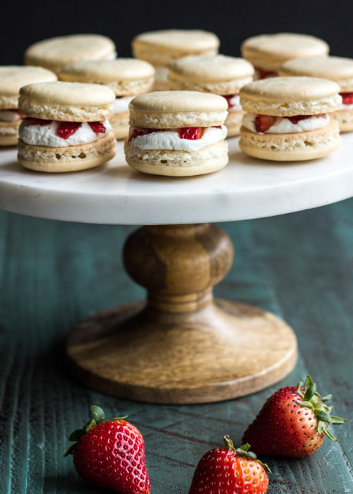 Strawberry Shortcake Macarons presented on a big tray with a few fresh strawberries under it