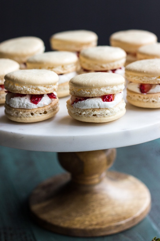 Fantastic closeup of Strawberry Shortcake Macarons served on a white tray on a stand