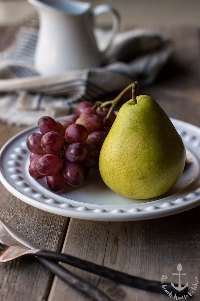 A bunch of grapes and a pear on a plate