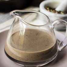 Bourbon Peppercorn Sauce served in a big glass jar on top of a plate