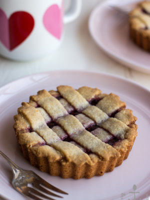 Miniature Linzer Torte on a pink plate with a fork