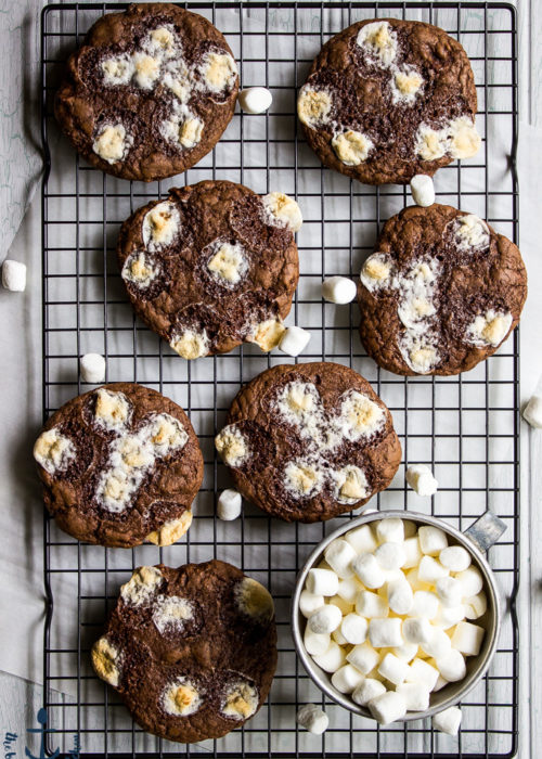 Hot Chocolate Marshmallow Cookies on baking rack with a silver cup filled with mini marshmallows.