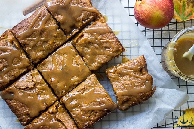 Overhead photo of Caramel Glazed Apple Butter Blondies on a sheet of white parchment paper over a wire cooling rack.
