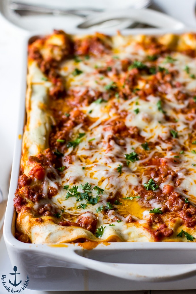 Ready homemade lasagna bolognese in a white baking pan looking extra delicious and inviting