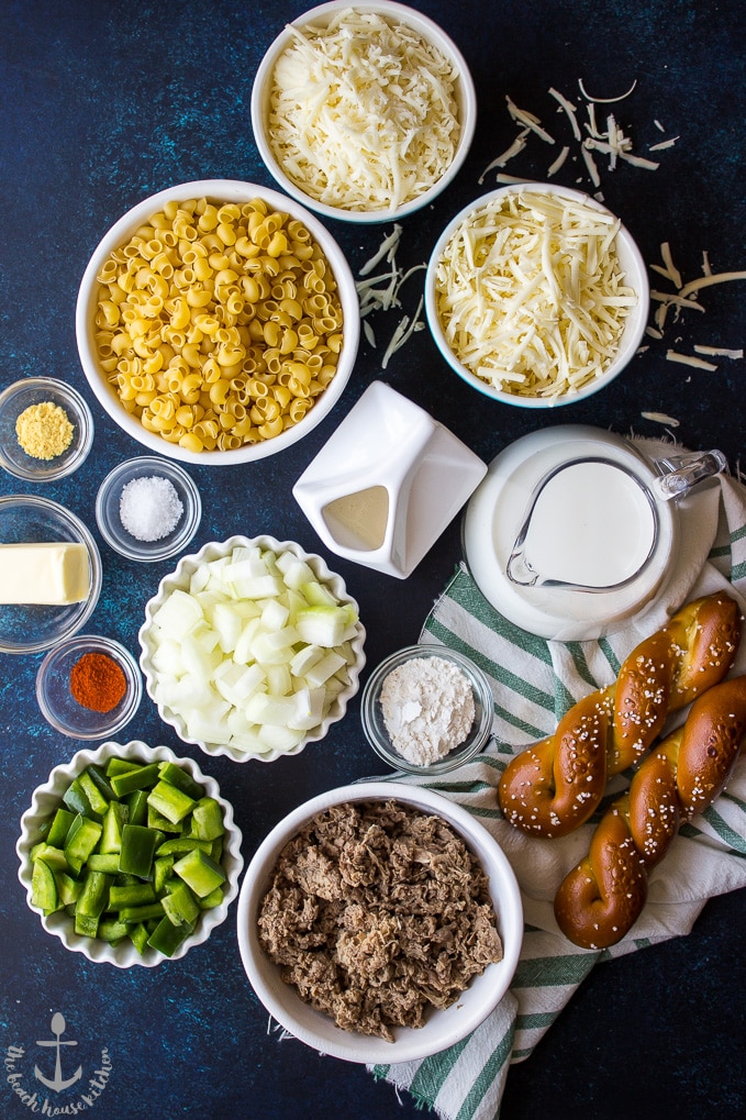 An overhead photo of ingredients for Philly Cheesesteak Macaroni and Cheese in individual bowls.