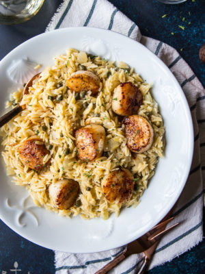 Overhead photo of the Pan Seared Scallops with Orzo Piccata looking extra delicious in a big white plate