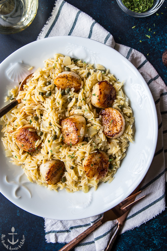 Overhead photo of the Pan Seared Scallops with Orzo Piccata looking extra delicious in a big white plate