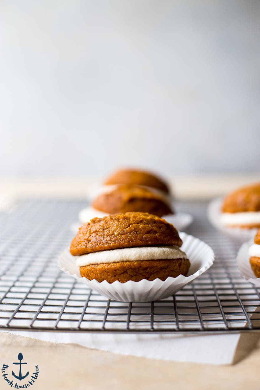 A Pumpkin Whoopie Pie on a wire rack in a paper cupcake liner