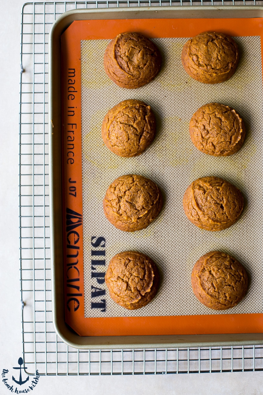 Overhead photo of pumpkin whoopie pie cakes on a silpat mat on a wire rack