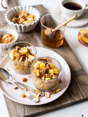 Two Peachy Quinoa breakfast bowls in glass cups on pink plate