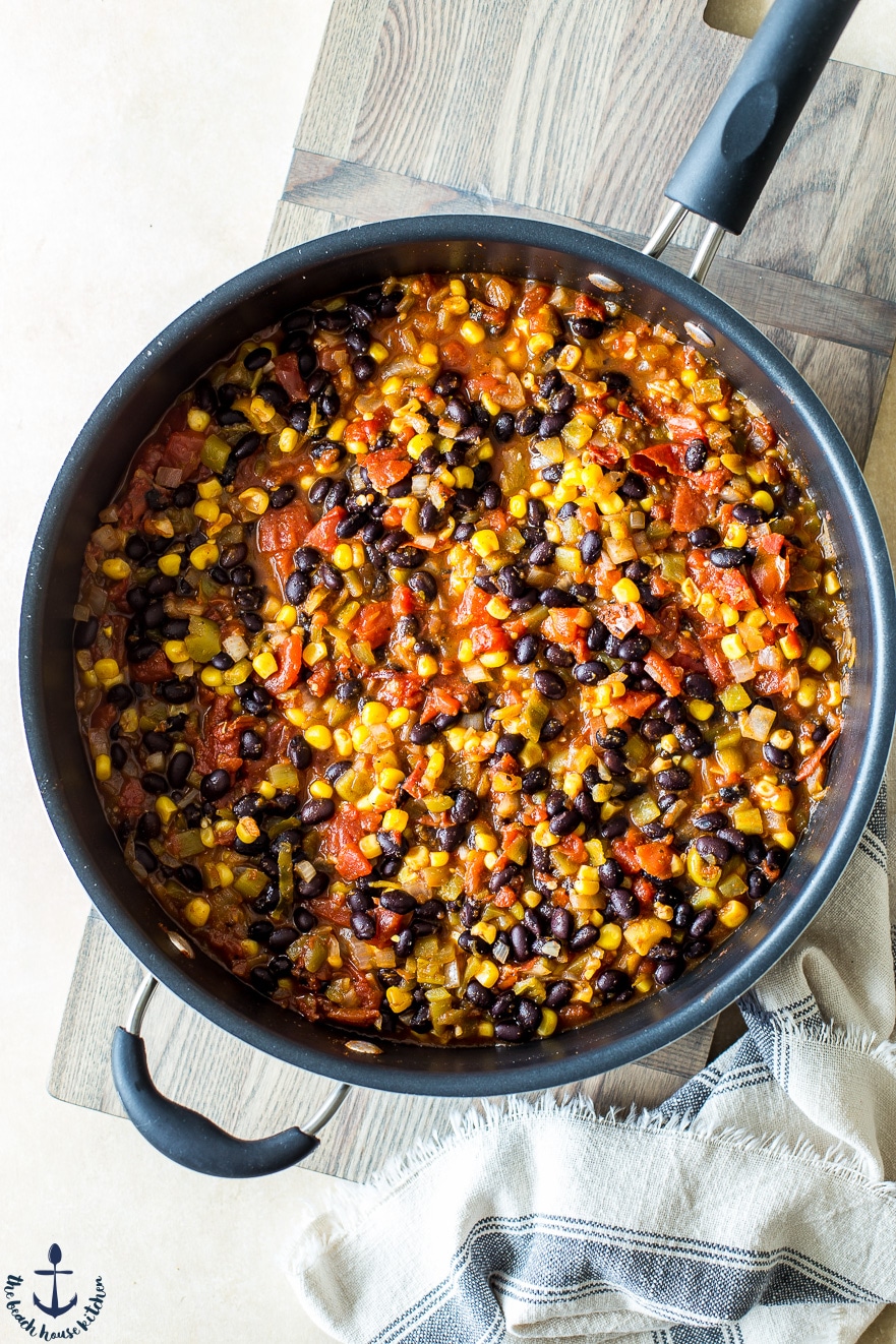Overhead photo of black beans, tomatoes and corn in a skillet