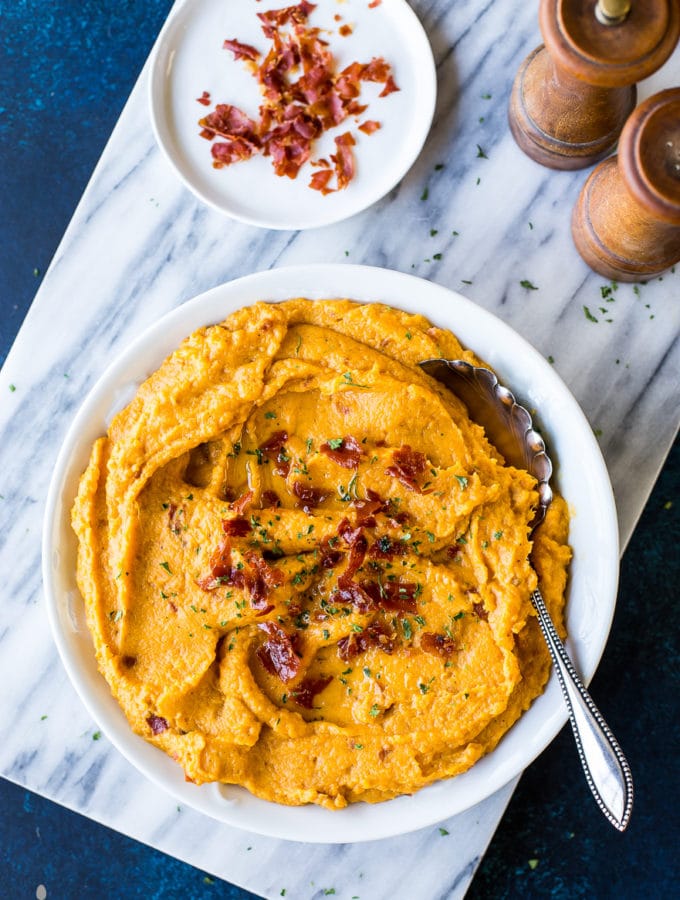 Overhead photo of mashed sweet potatoes topped with crsipy proscuitto