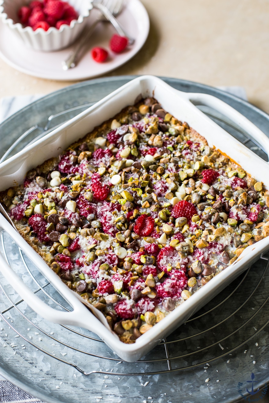 Photo of raspberry pistachio magic bars in white pan