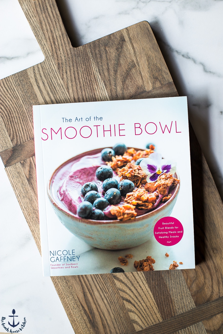 Overhead photo of The Art of the Smoothie Bowl cookbook on a wooden board