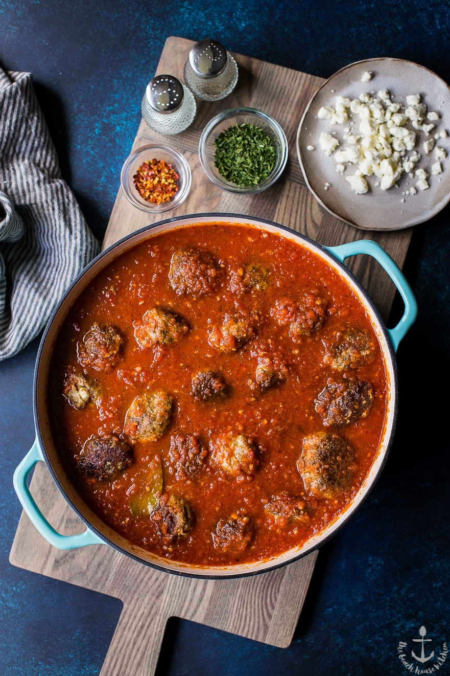 Overhead photo of Greek meatballs and gravy is a dish on a wooden board