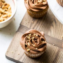 Overhead photo of banana cupcakes with chocolate buttercream on a wooden board