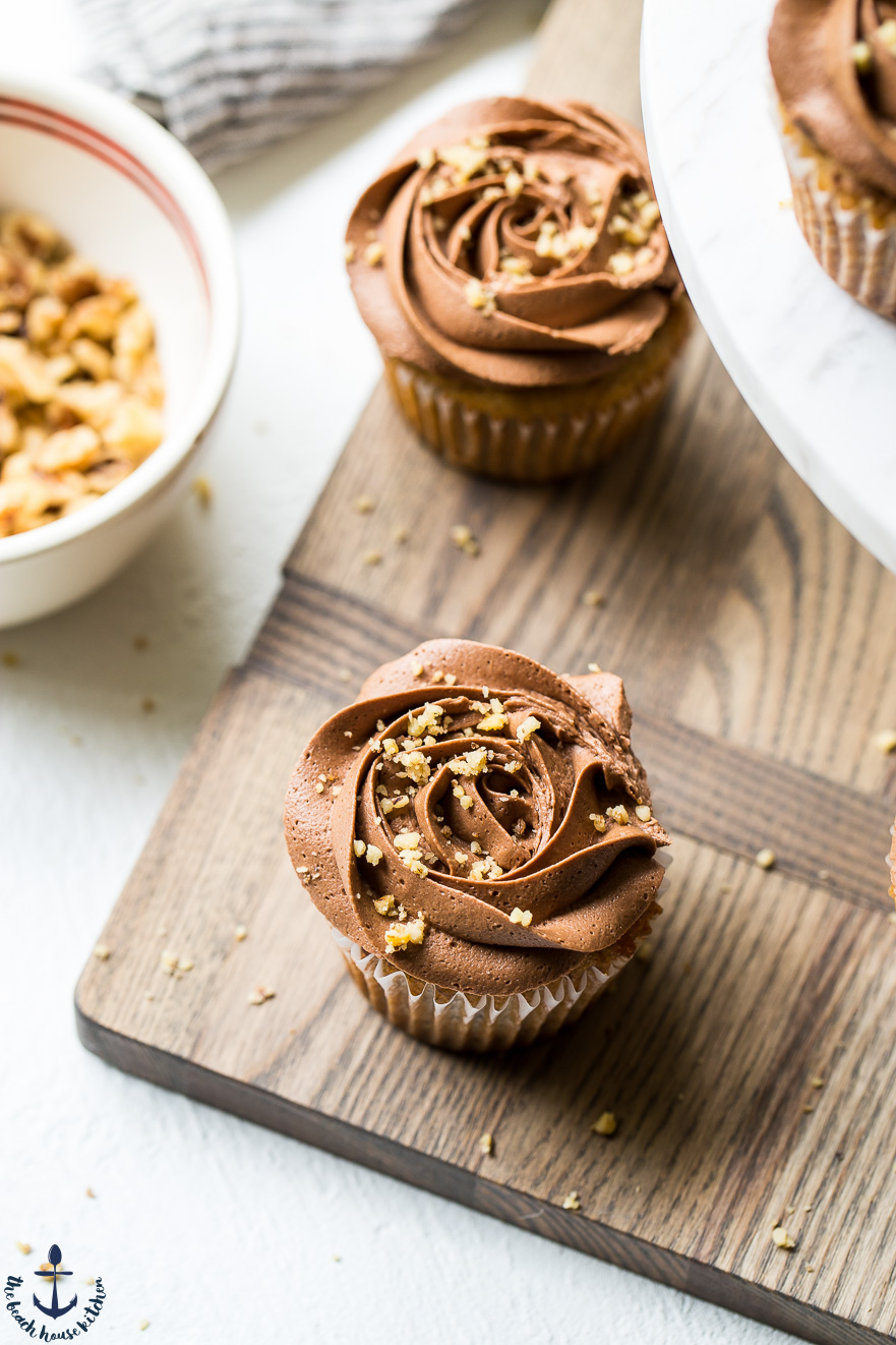 Overhead photo of banana cupcakes with chocolate buttercream on a wooden board