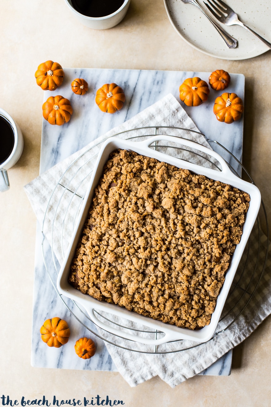 Overhead photo of pumpkin crumb snack cake in a white baking dish on a marble board