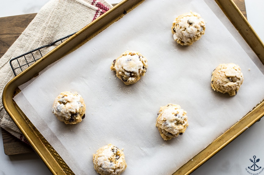 Overhead photo of pre-baked chocolate chip toasted coconut scones on a baking sheet
