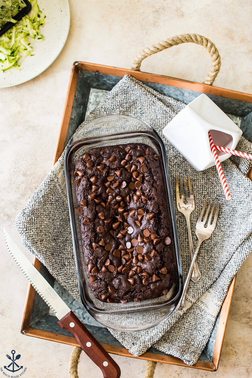Overhead photo of chocolate zucchini bread in glass loaf pan on a tray