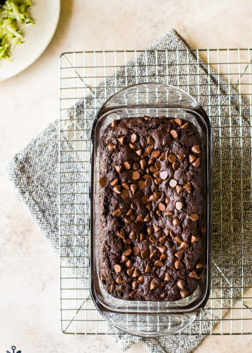 Overhead photo of chocolate zucchini bread in glass loaf pan on wire rack