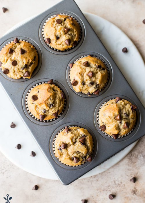 Overhead photo of Easy Chocolate Chip Muffins in muffin tin on a round white marble board