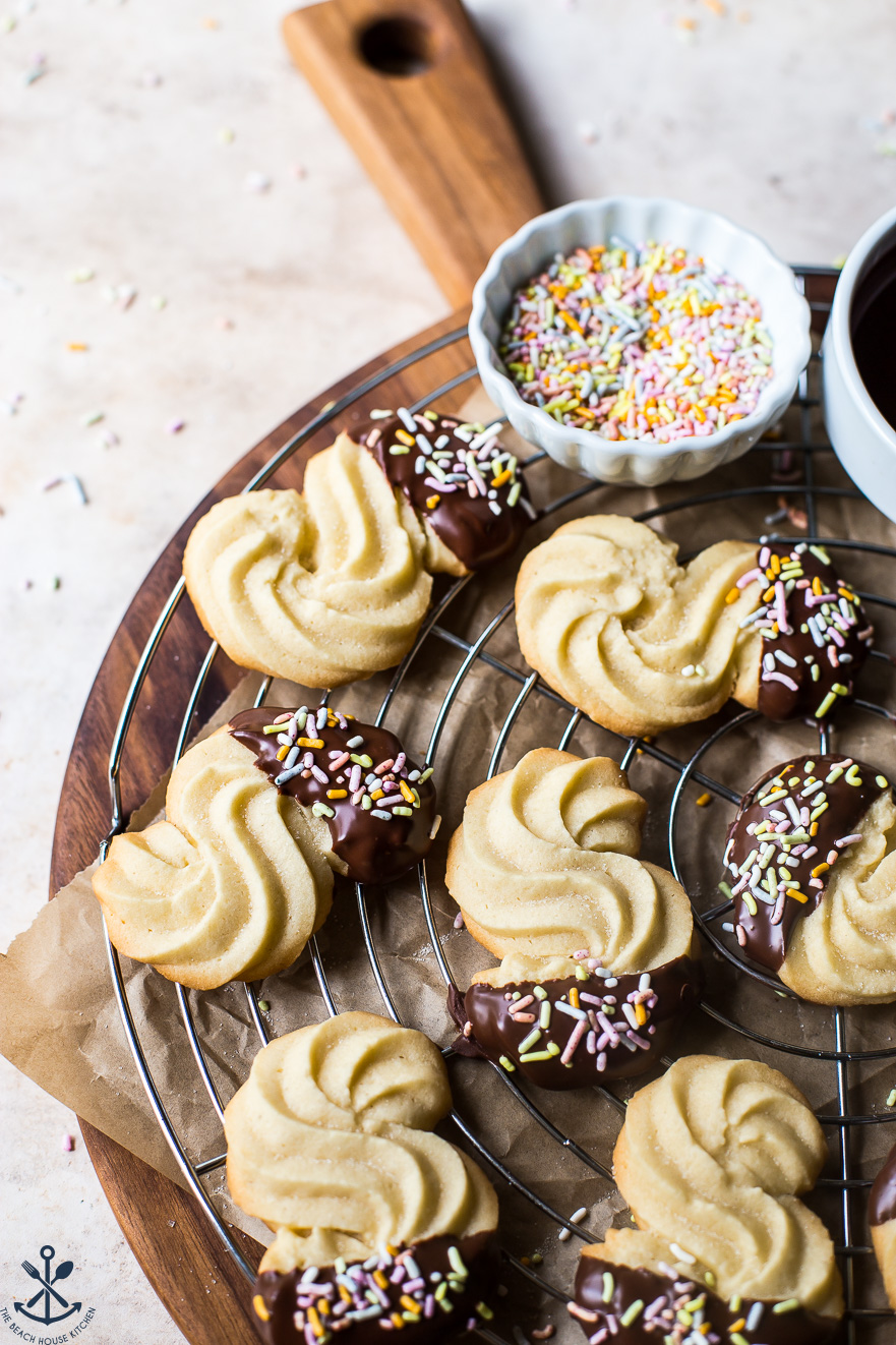 Chocolate Dipped Danish Butter Cookies on a round wire rack on a wooden board