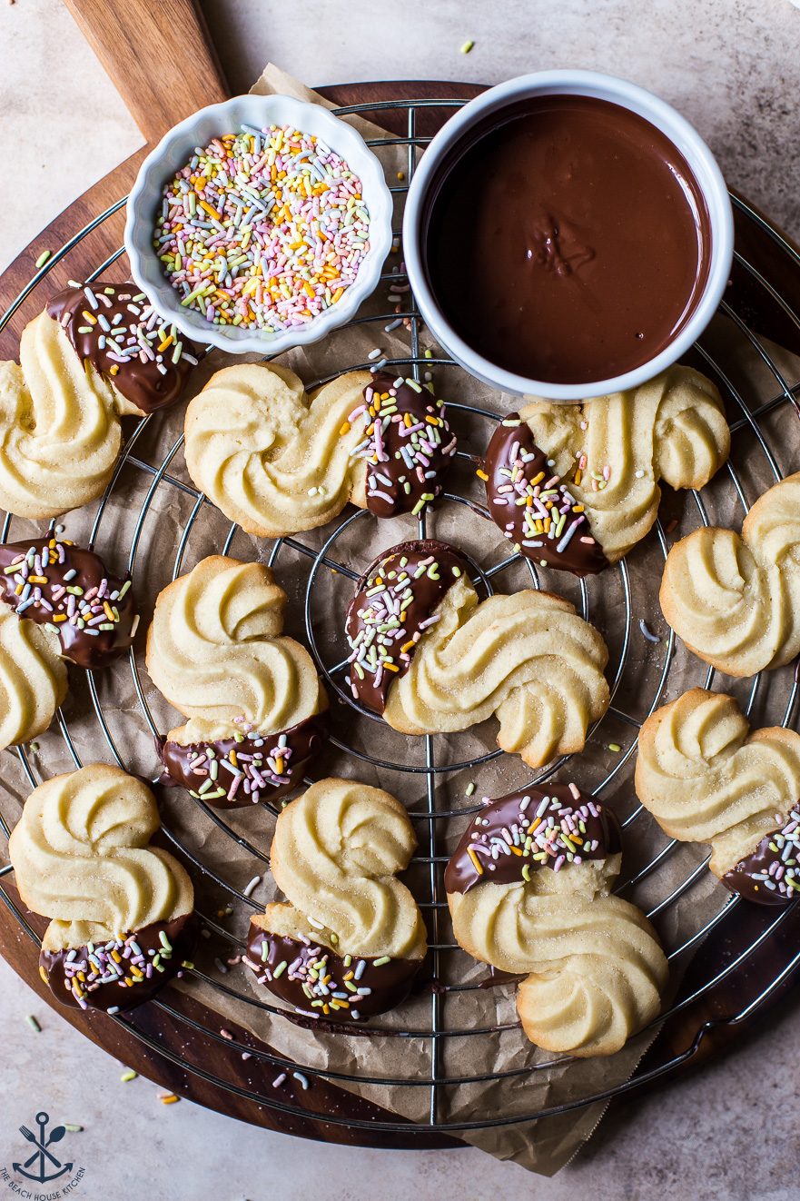 Overhead photo of Chocolate Dipped Danish Butter Cookies on a round wire rack on a wooden board