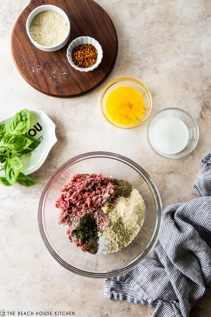 Overhead photo of ingredients for meatballs in glass bowls