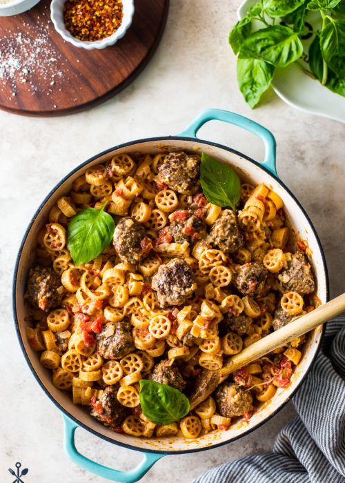 Creamy Tomato Pasta with Meatballs in a round turquoise colored baking dish