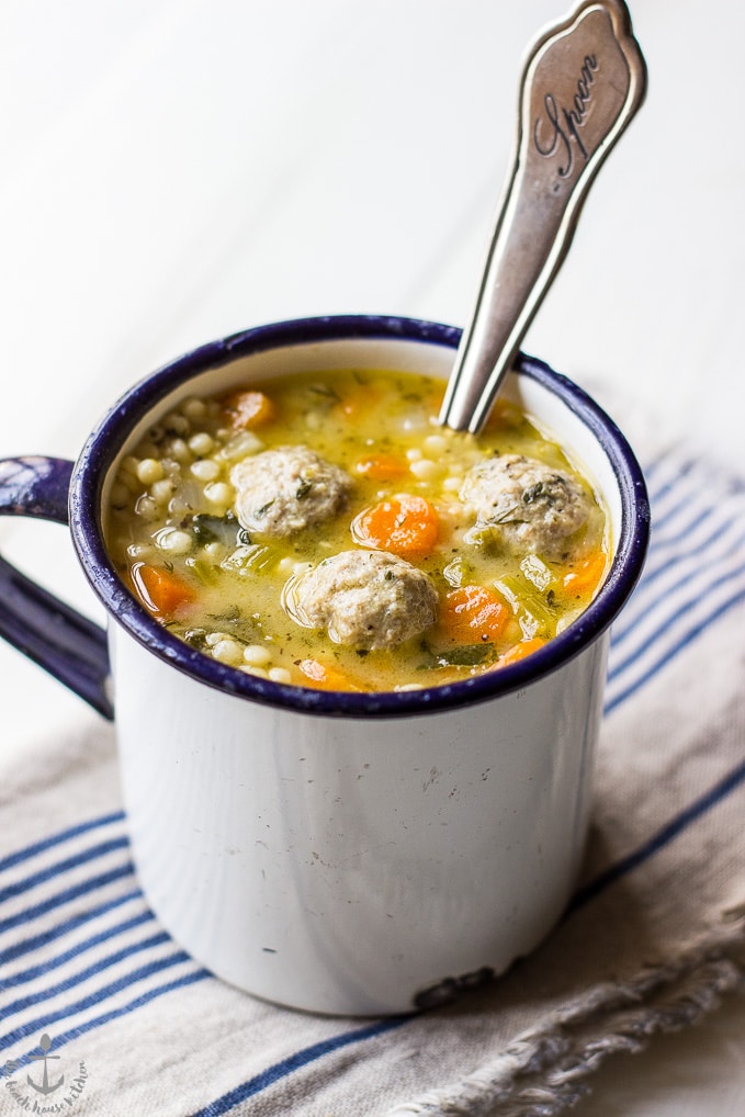 Italian Wedding soup in a white mug with a spoon