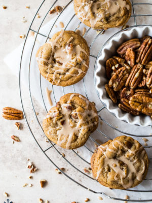 Overhead photo of Brown Sugar Praline Cookies with Praline Cinnamon Glaze on a wire rack with a bowl of pecans