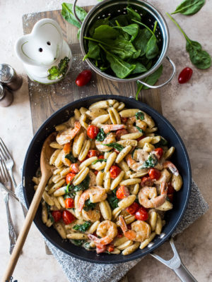 Overhead photo of skillet filled with Shrimp Pasta with Garlic Cream Sauce Tomatoes and Spinach