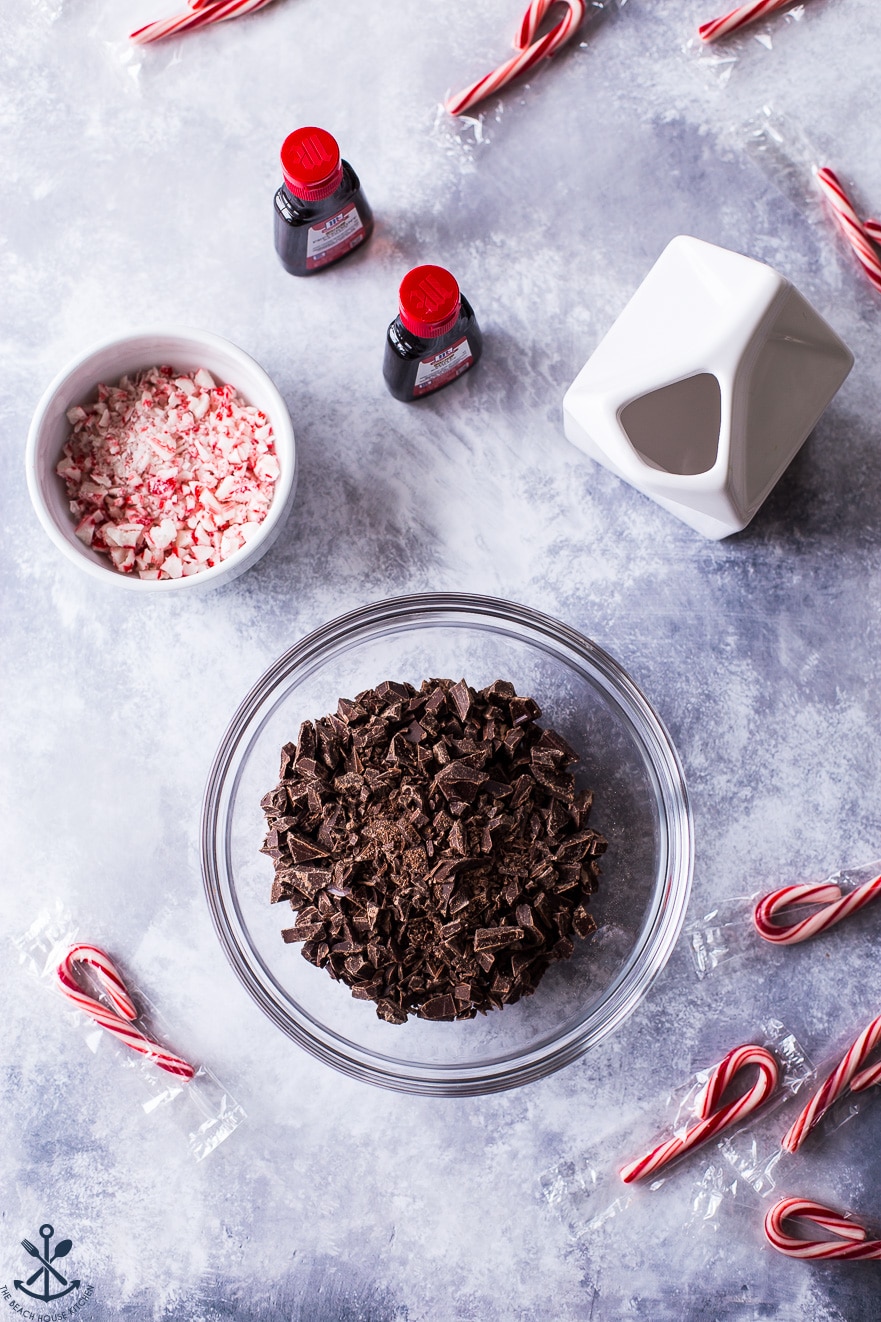 Overhead photo of ingredients for chocolate peppermint ganache in bowls on a marble background