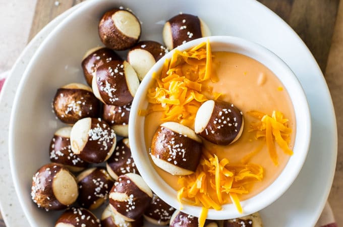 Easy Creamy Beer Cheese Dip in a bowl surrounded by pretzel nuggets