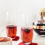 Up close photo of Chambord Fizz and Gummies with a bottle of Chambord in the background