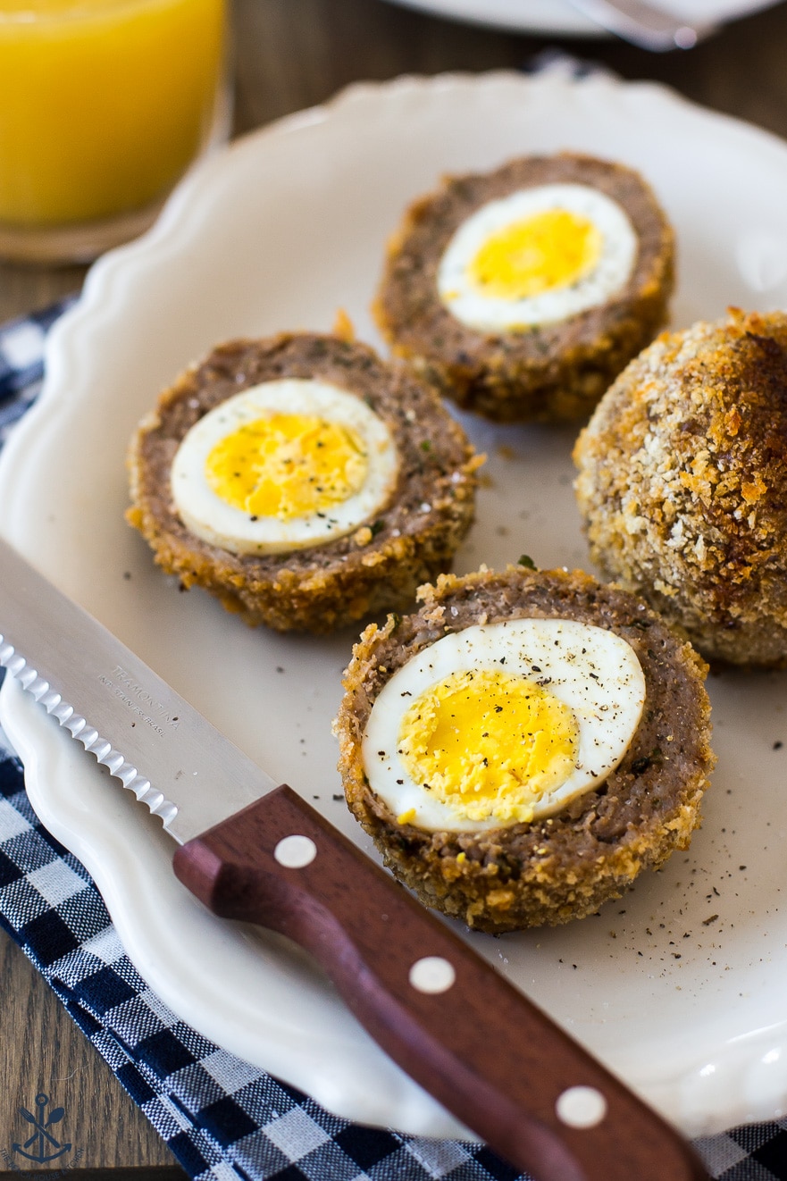 Plate of scotch eggs with a sharp knife with a wooden handle