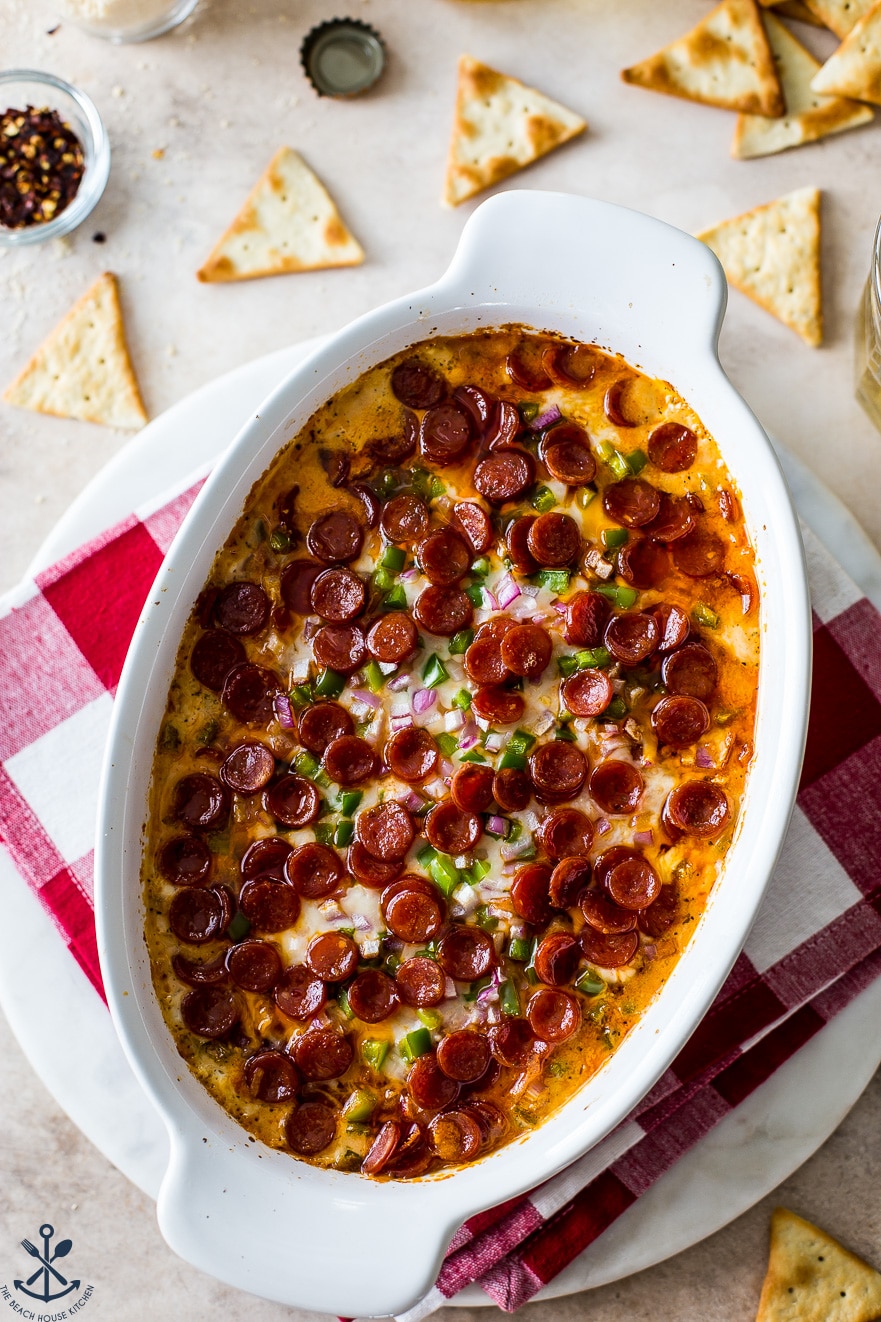 Overhead photo of a pepperoni dip in a white oval dish looking extra inviting