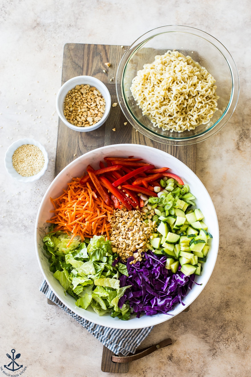 Overhead photo of ingredients for ramen noodle salad in bowls on a wooden board
