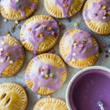 Up close overhead photo of purple Glazed Blueberry Hand Pies with sprinkles