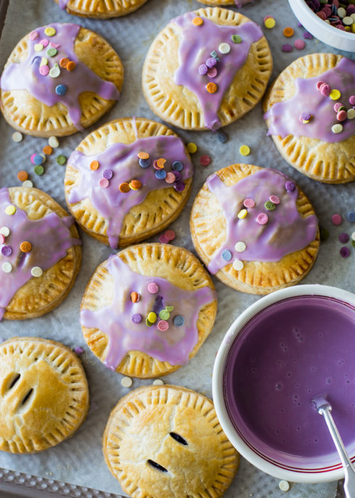 Up close overhead photo of purple Glazed Blueberry Hand Pies with sprinkles
