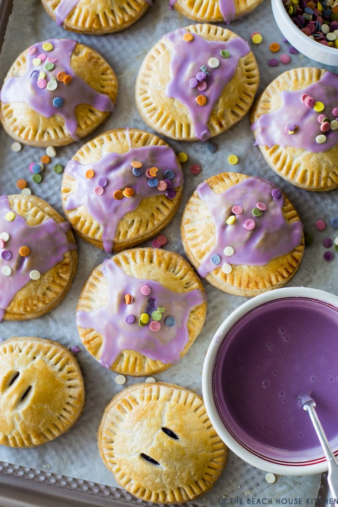 Up close overhead photo of purple Glazed Blueberry Hand Pies with sprinkles