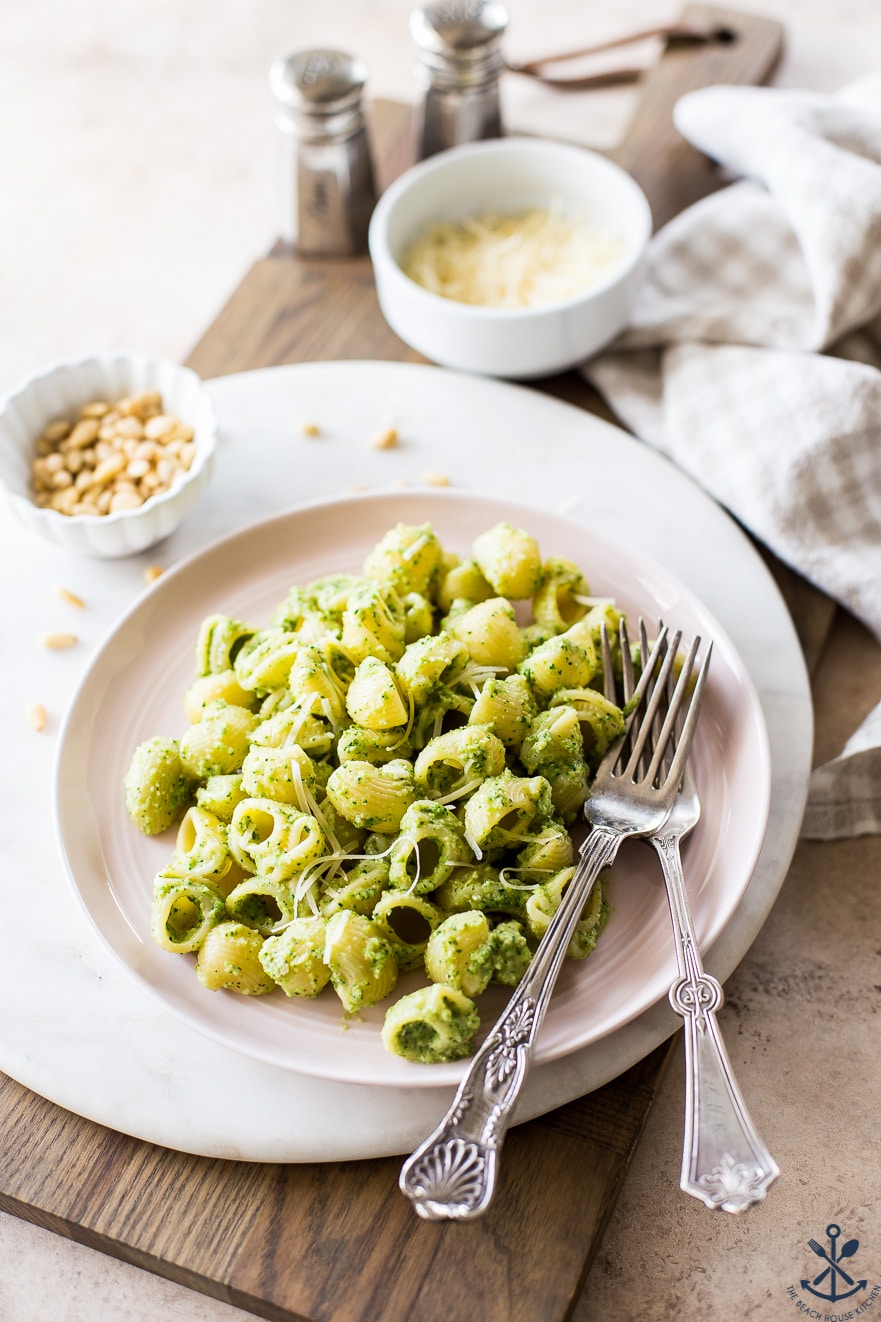 A light pink dish of pesto pasta with two forks