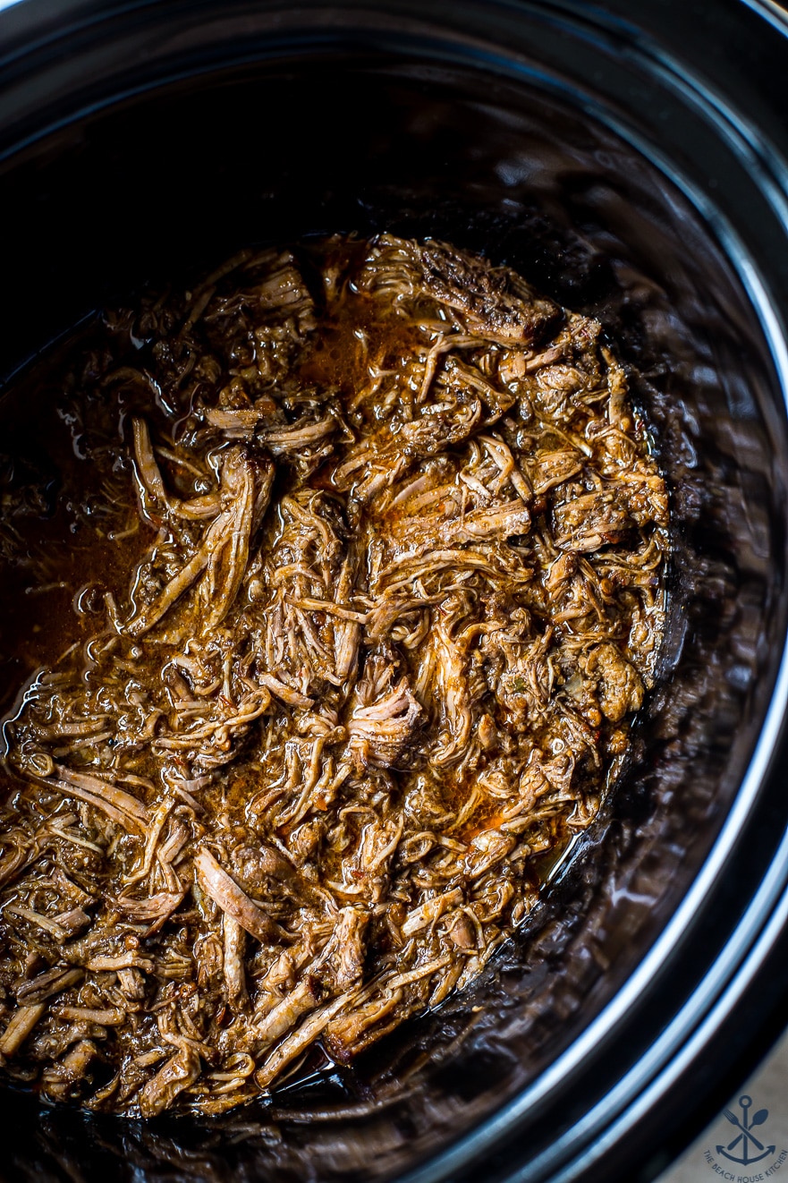 Up close overhead photo of shredded beef in a slow cooker