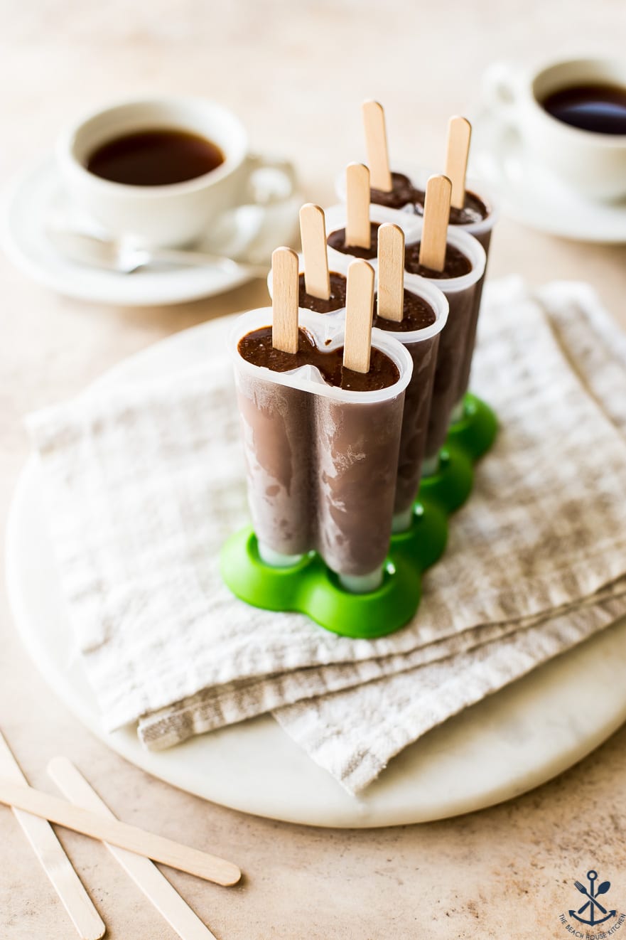 Chocolate popsicles in a popsicle mold with a green bottom