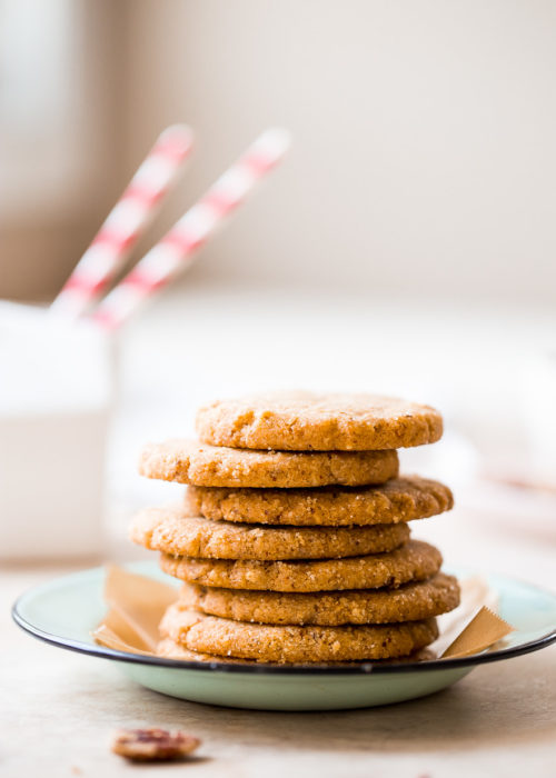 Up close photo of a stack of pecan sandie cookies on a plate