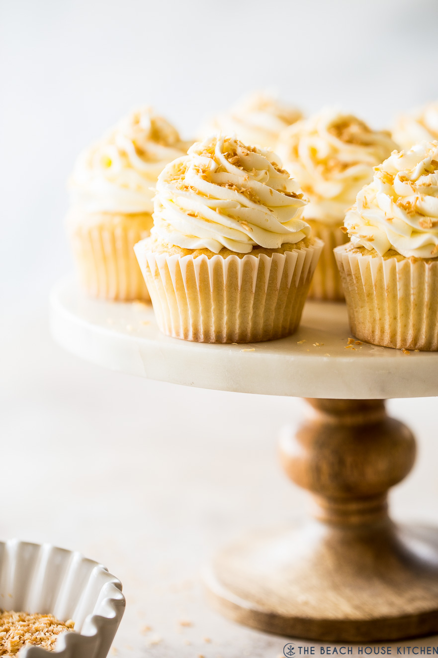 Up close photo of Pina Colada Cupcakes on a cake stand