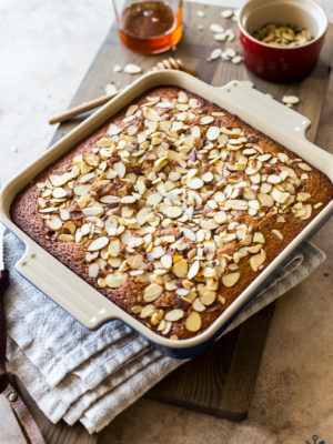 Easy Spiced Honey Snack Cake topped with almonds in a square baking pan
