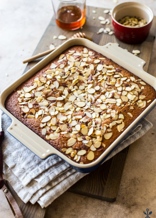 Easy Spiced Honey Snack Cake topped with almonds in a square baking pan